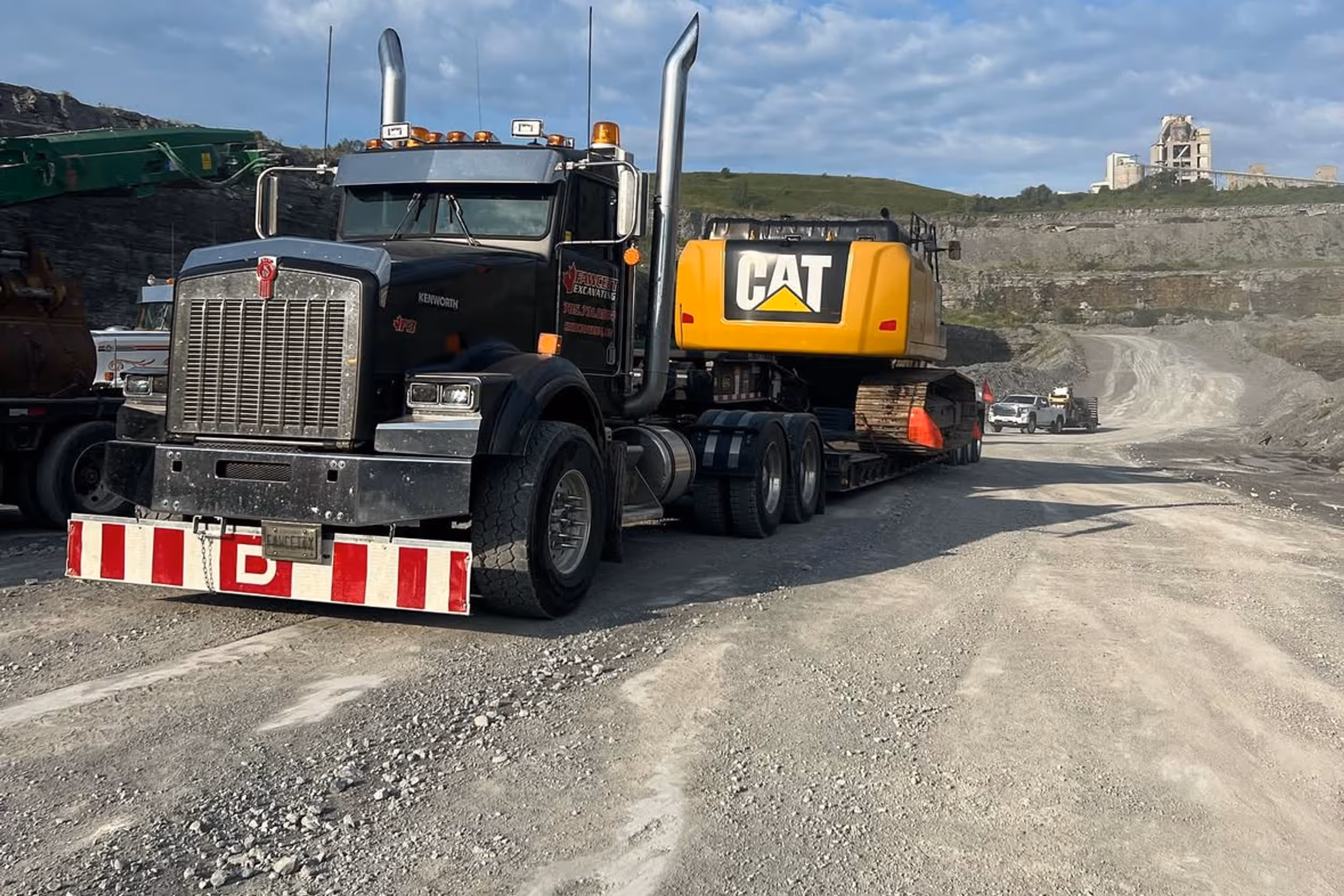 Excavator and dump truck working on a gravel driveway construction project in Bobcaygeon