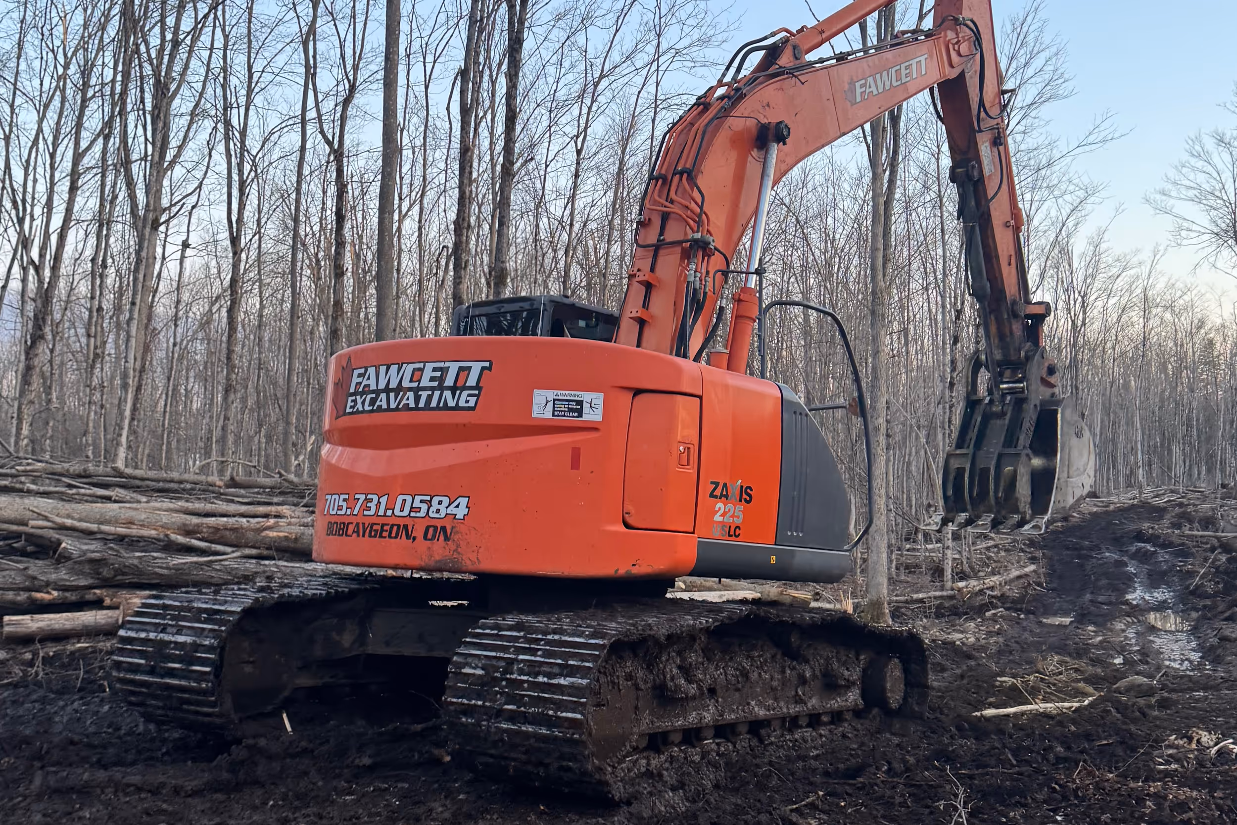 Excavator clearing trees and brush on a lot in Bobcaygeon