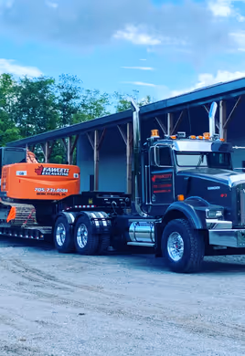 Transport truck hauling excavator